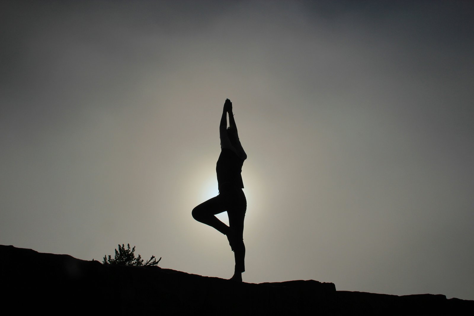 Personne en posture de yogae au lever du soleil